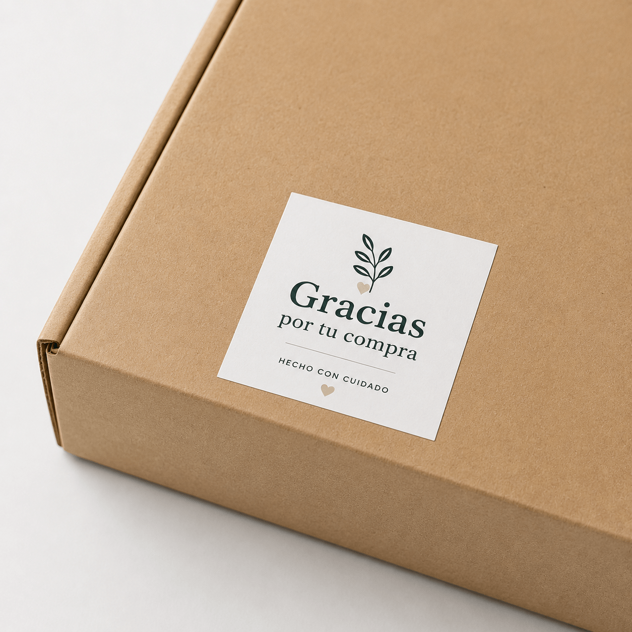 Pegatina personalizada cuadrada sobre caja de ecommerce con el mensaje "Gracias por tu compra"